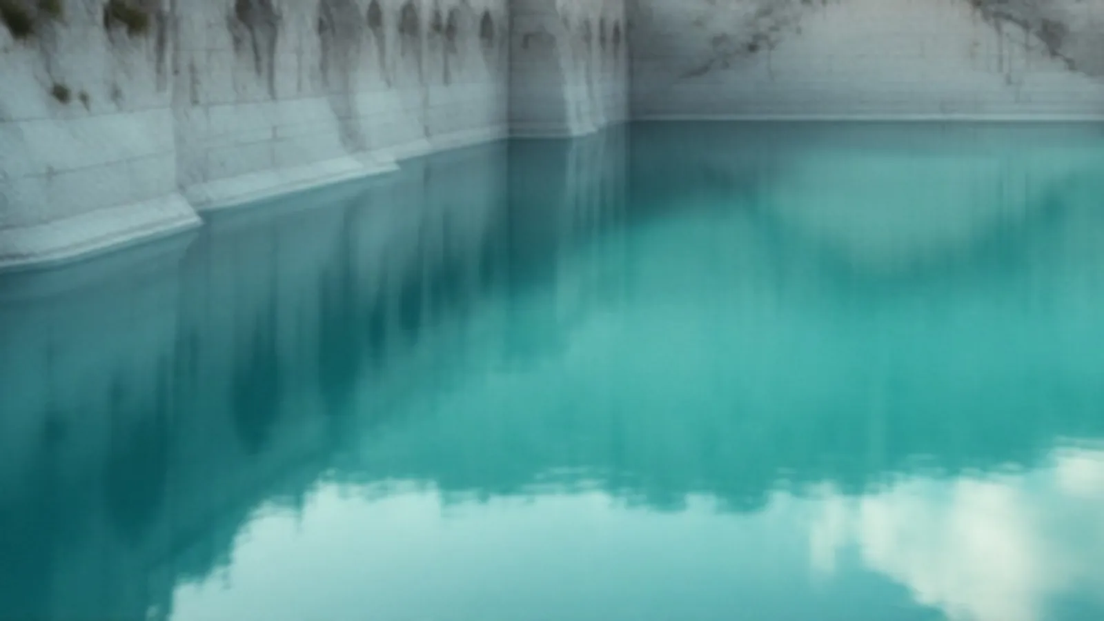A flooded quarry with clear turquoise water and pale stone walls under soft morning light, the FinanceQuarry view of online loans for any credit, $100 – $5,000